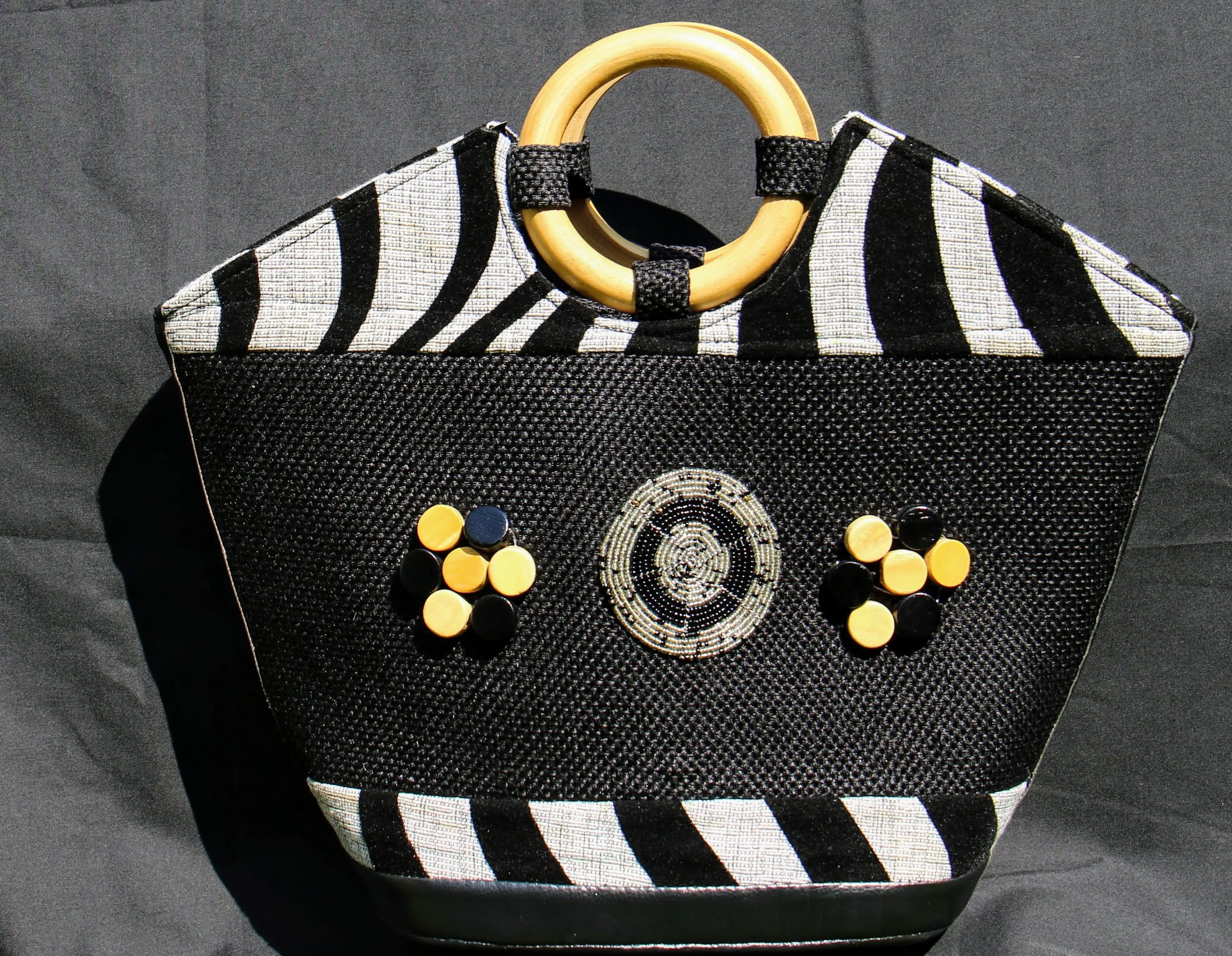 Boat-shaped Handbag with Wooden handle and embellished with beads.